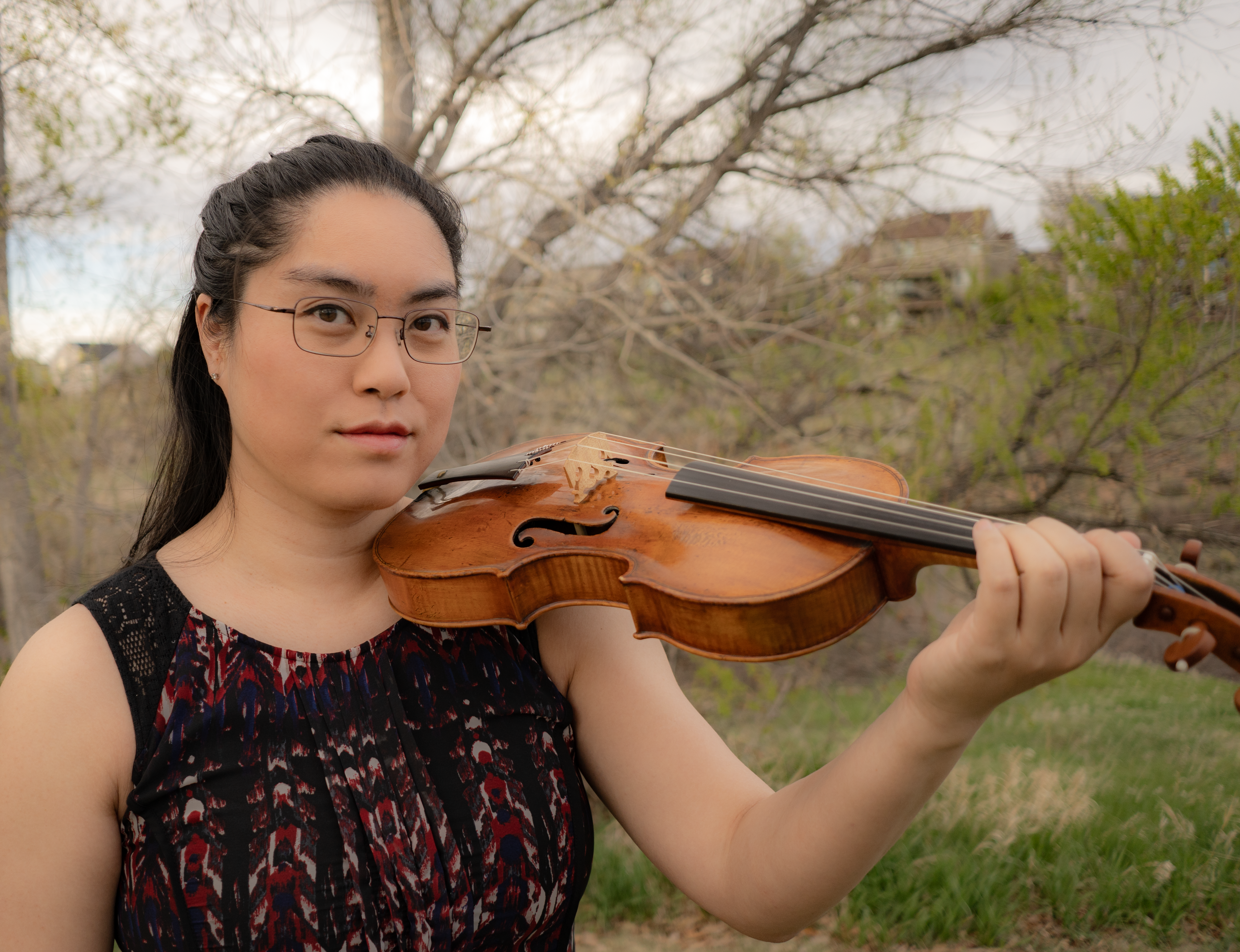 Violinist Julia Taylor standing in front of a tree